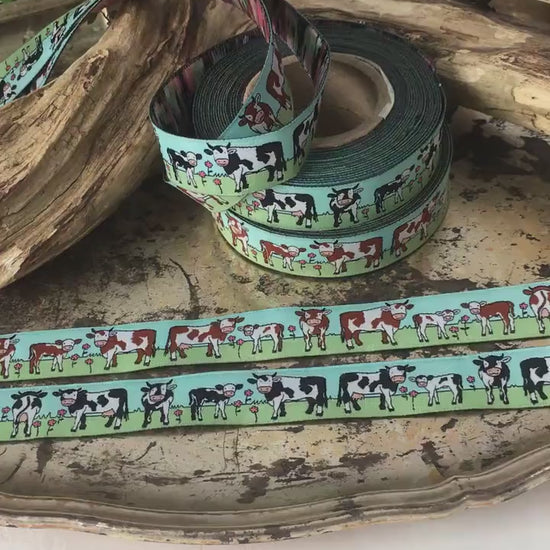 Das Video zoomt and die beiden Webbänder mit schwarz-weißen und braun-weißen Kühen heran und zeigt sie im Detail um Struktur und Materialbeschaffenheit zu erkennen.