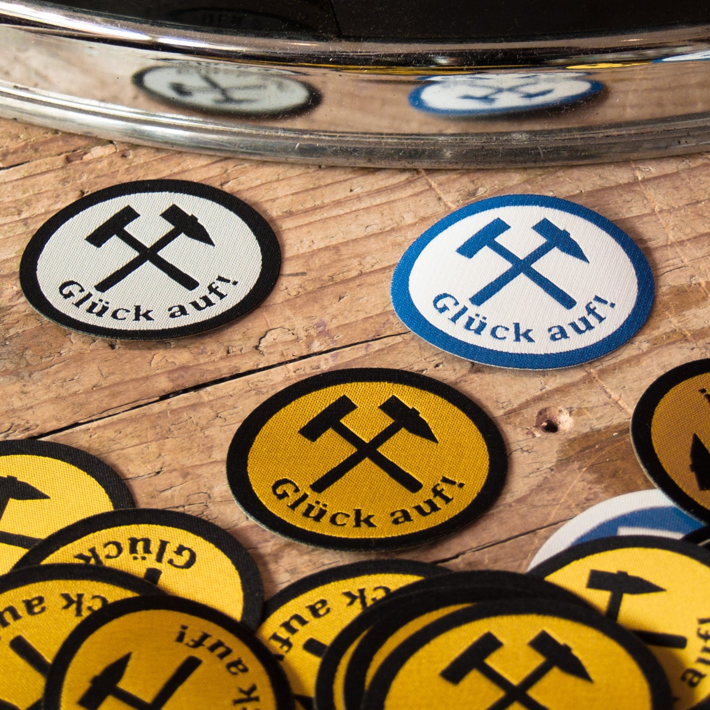 3 ovale Aufnäher mit dem Spruch Glück auf und Schlägel und Eisen in schwarz mit weiß, blau mit weiß und schwarz mit gelb.