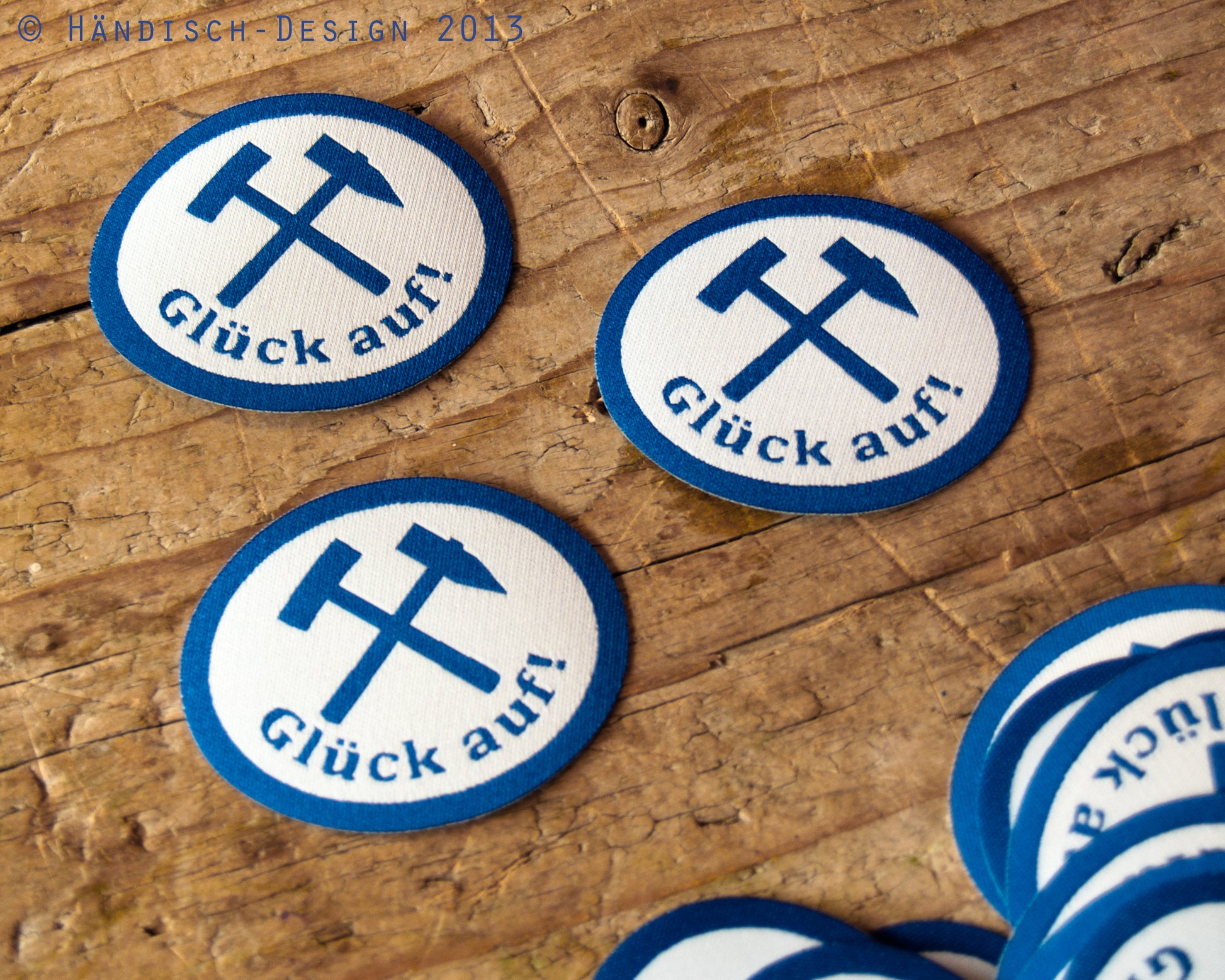 3 ovale Aufnäher mit dem Spruch Glück auf und Schlägel und Eisen in blau mit weiß.