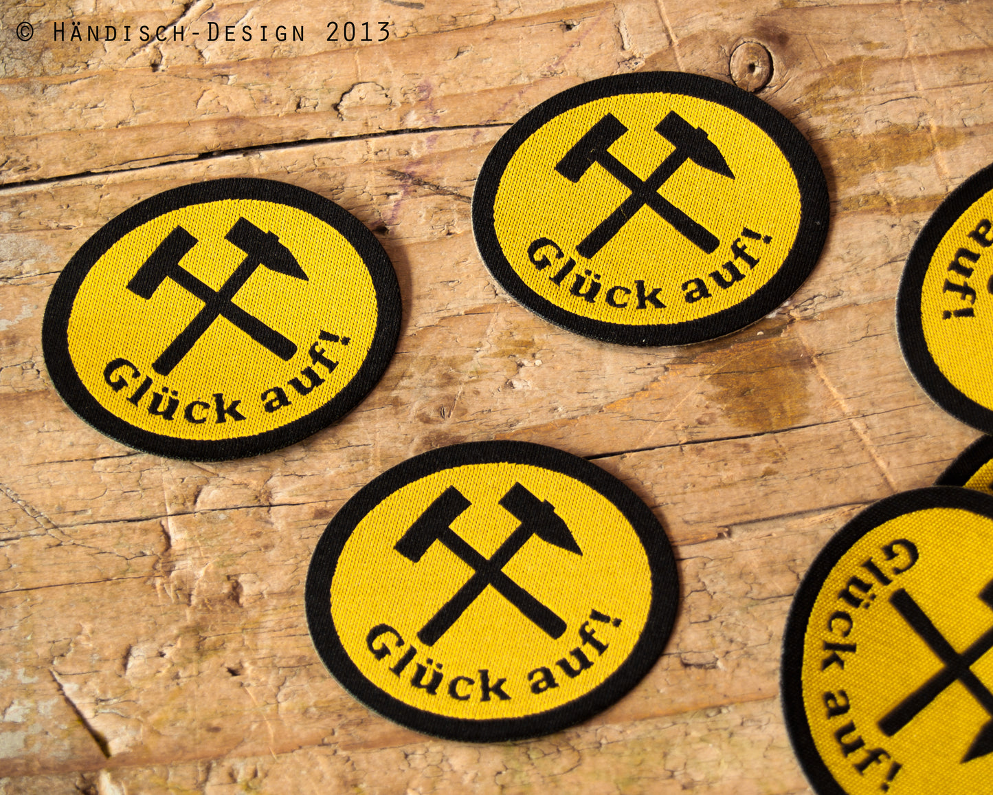 3 ovale Aufnäher mit dem Spruch Glück auf und Schlägel und Eisen in schwarz mit gelb.