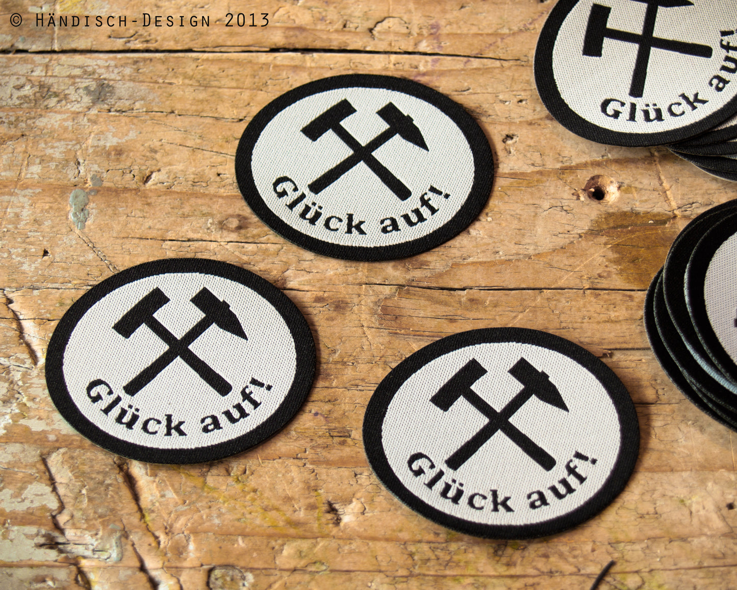 3 ovale Aufnäher mit dem Spruch Glück auf und Schlägel und Eisen in schwarz mit weiß.