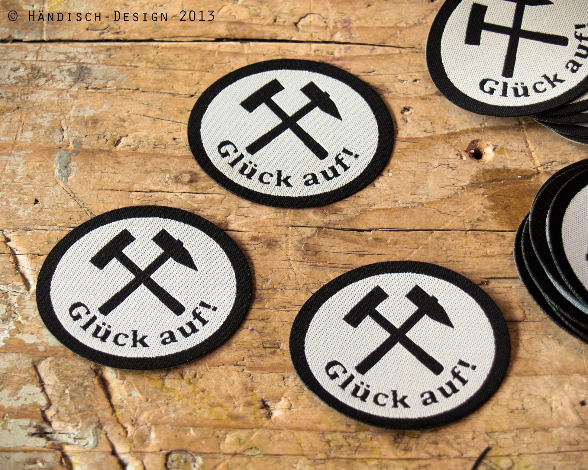3 ovale Aufnäher mit dem Spruch Glück auf und Schlägel und Eisen in schwarz mit weiß.